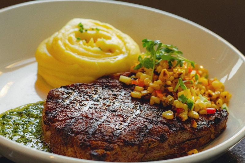 Grilled steak sliced over whipped potato with corn salsa.