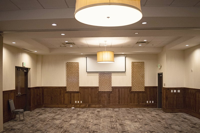 An unset private room at Elements with wainscot and drum pendant lights.