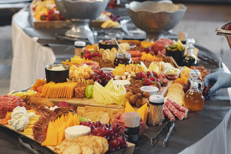 A full grazing table laid with charcuterie, cheeses, fresh fruit and honey.