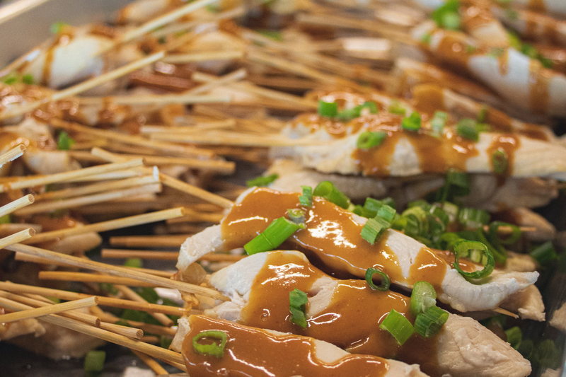 Chicken satay skewers, glazed and garnished, filling the frame.