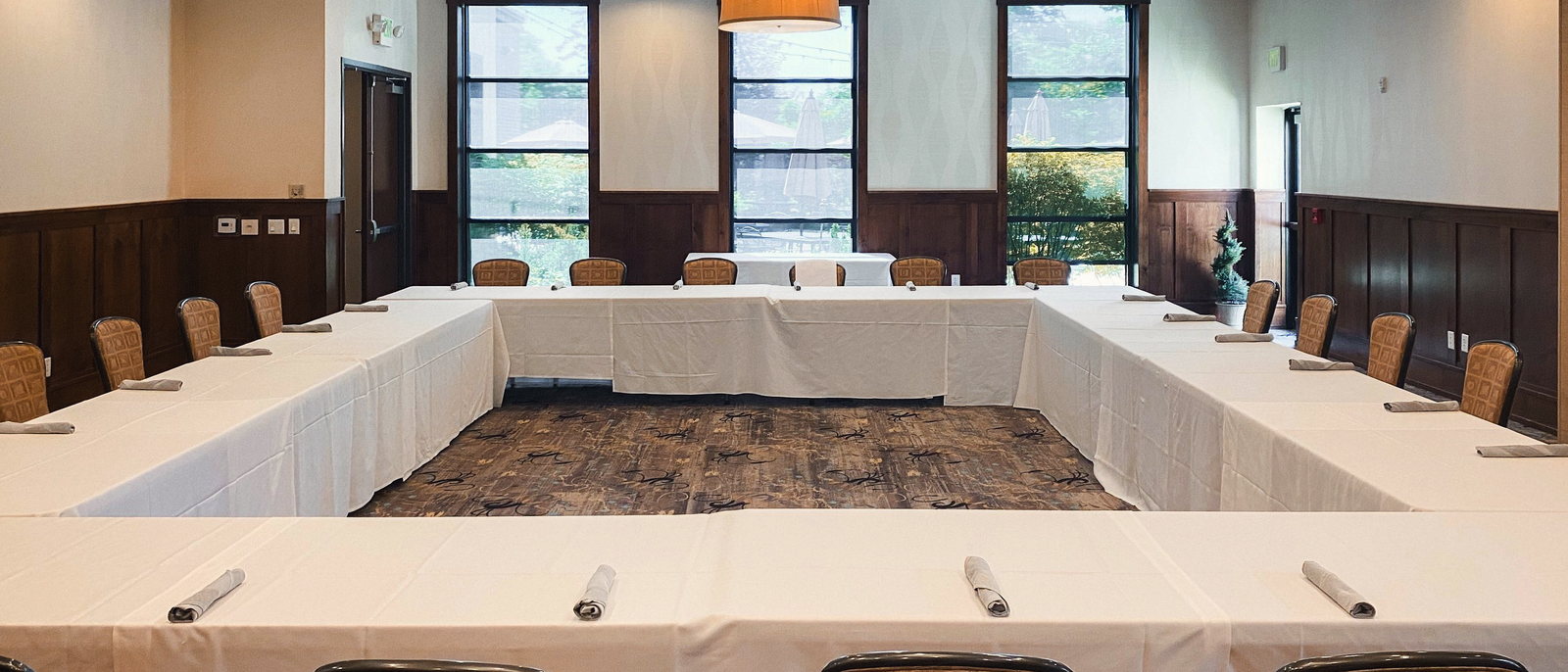 The Maple room set in a hollow square, with wainscot panelling and daylight from two western windows.