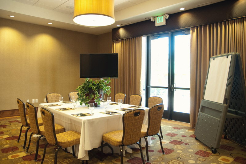 The Cherry set as a boardroom for ten, with a wall-mounted display and a flip chart at the head of the table.