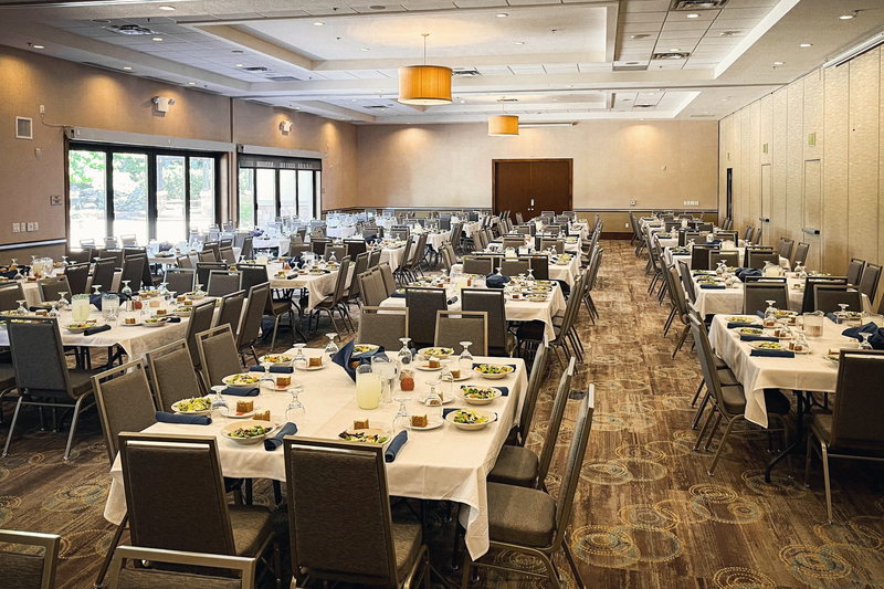 Mahogany and Redwood opened into one room and set for a plated banquet, with round tables, gold chairs and elevated ceilings.