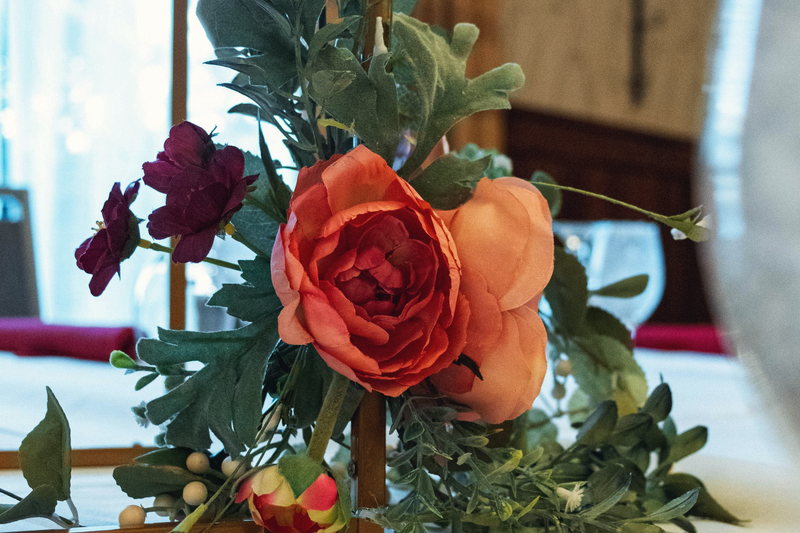 Fresh florals and eucalyptus tied along a gold geometric wedding arch.